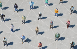 Many people standing six feet apart